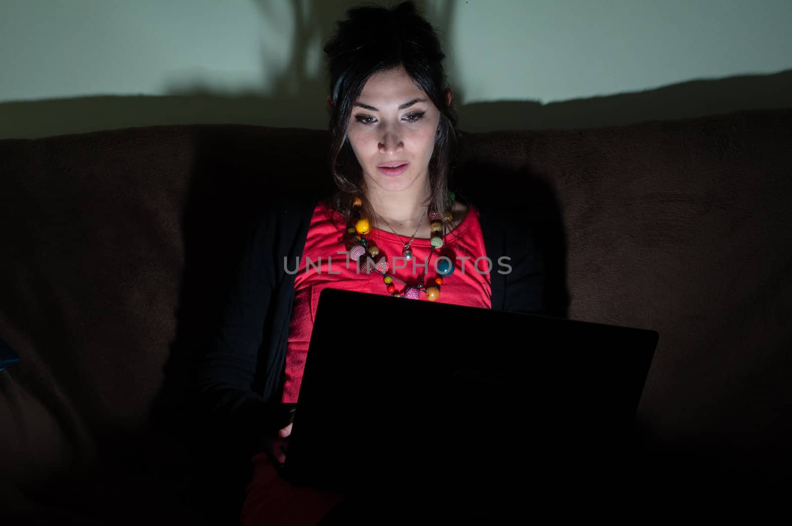 woman at home using notebook on couch