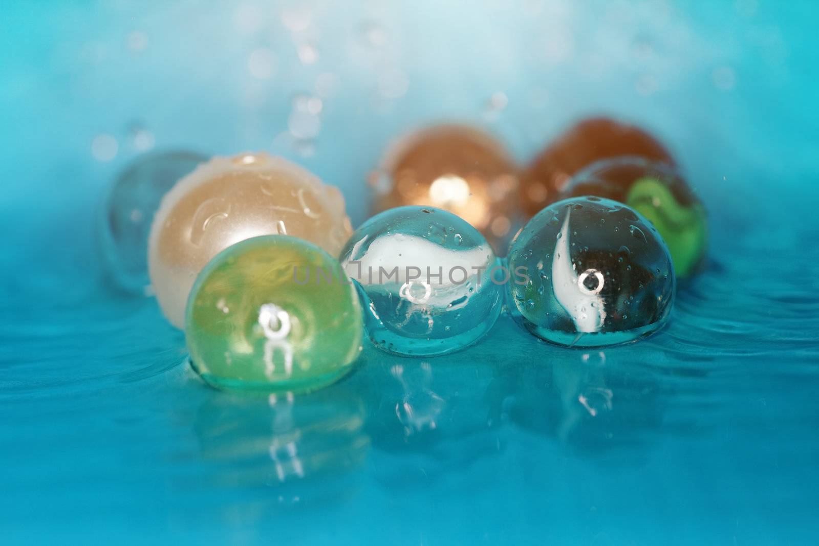 Extremely close-up macro photo of the glassy balls in the water. Shallow depth of field for natural view