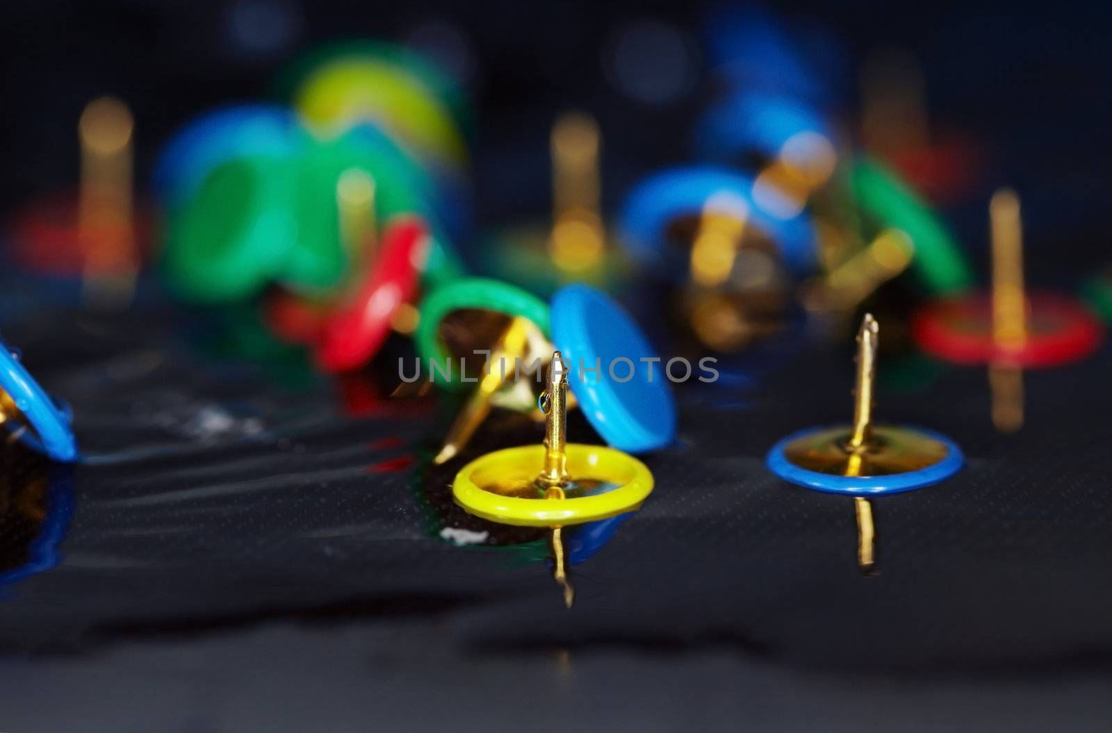 Extremely close-up macro photo of the pushpins in the water. Shallow depth of field and vibrant color for natural view