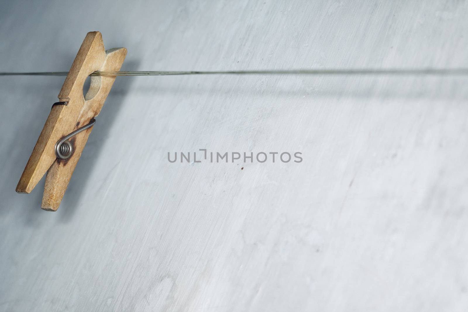 Close-up horizontal photo of the old wooden clothes pin hanged on a clothes-line