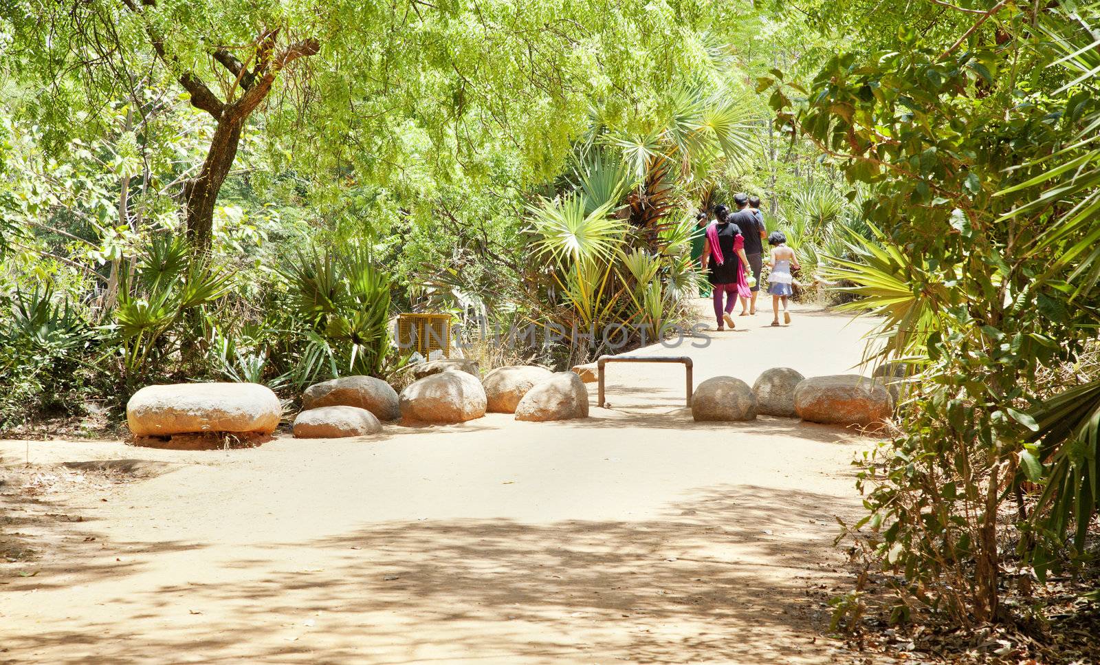 landscape of a family walking to the car park after visiting the Matramandir at Auroville in Tamil Nada India. One of the cleanest and environment friendly palces to be seen in India. They even have litter bins that the public seem to use. Amazing. Unique obstacles to prevent bike riding.