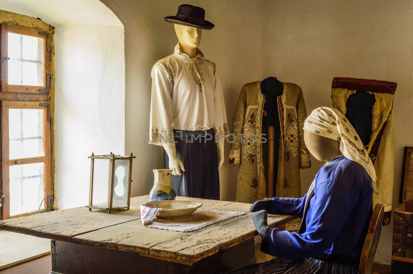 mannequins dressed in traditional clothes next to a window