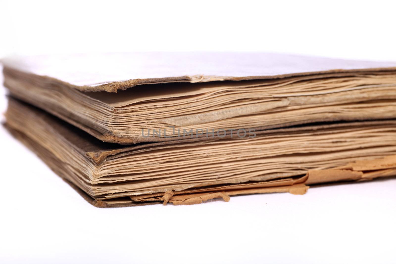 Vintage books with distressed covers and worn discoloured pages, corner angle view on a white background