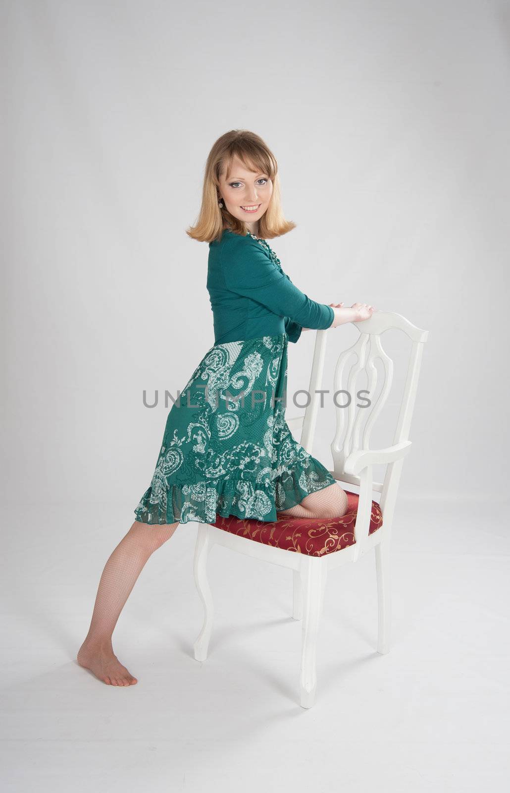 beautiful woman in a green dress sitting on a chair