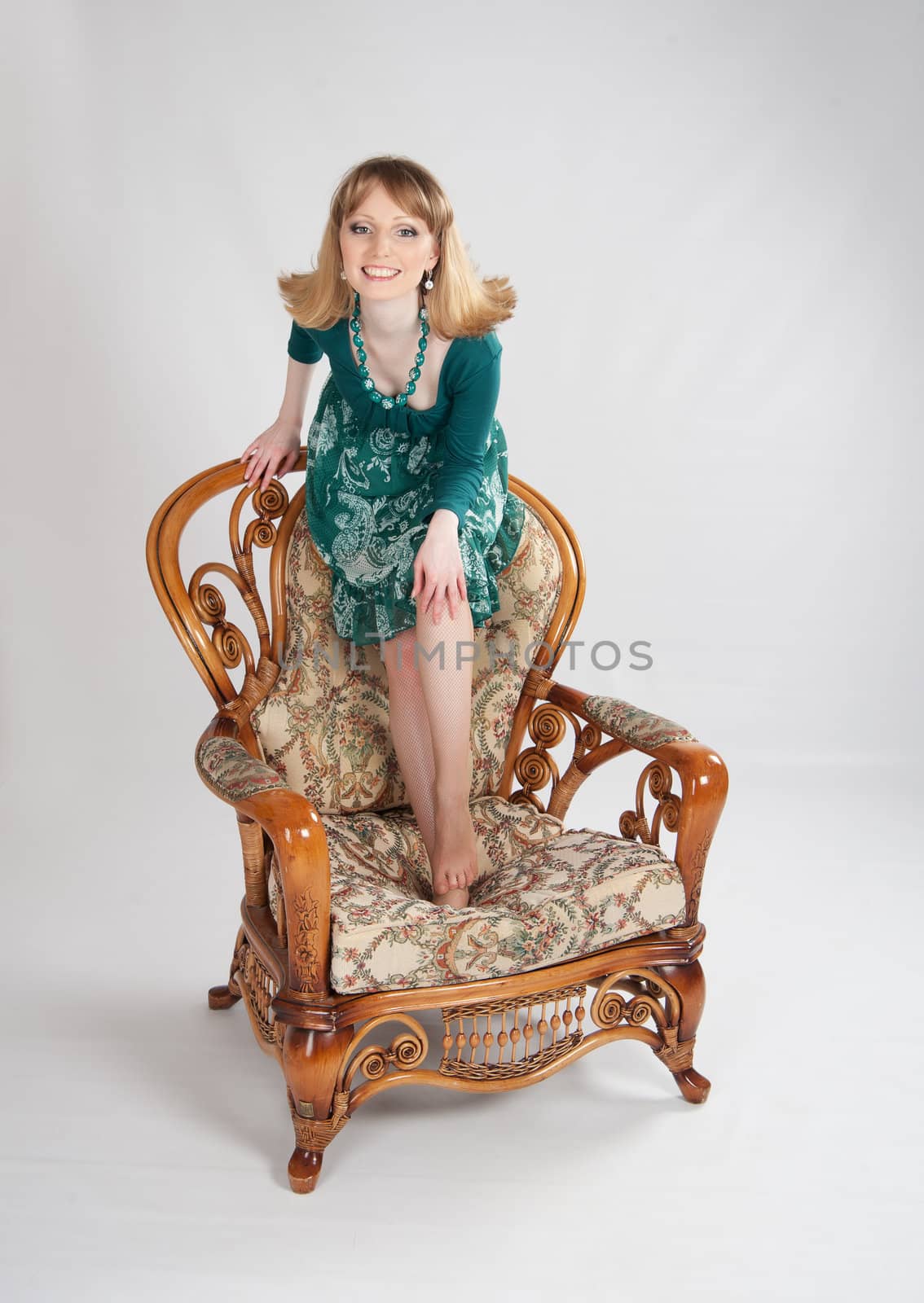 beautiful woman in a green dress sitting on a chair