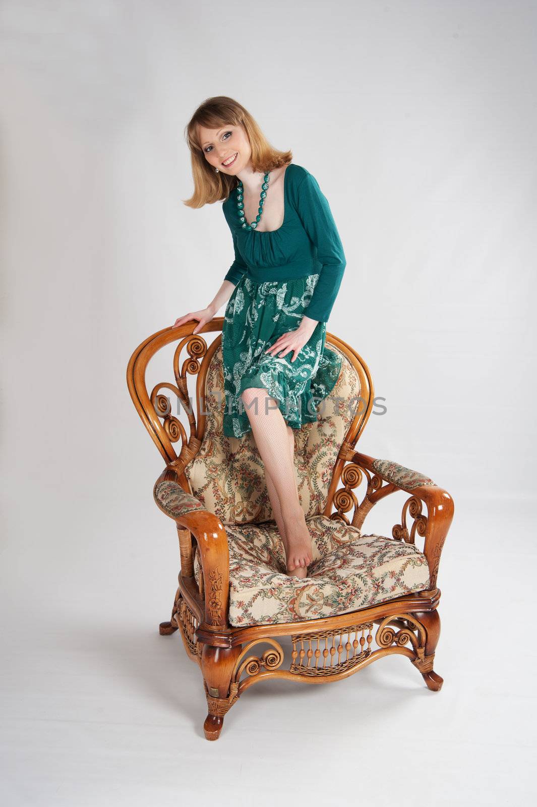beautiful woman in a green dress sitting on a chair