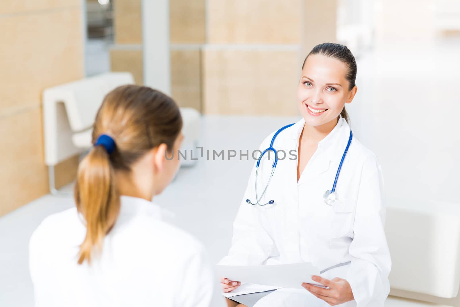 two doctors talking in the lobby of the hospital, sitting on the couch