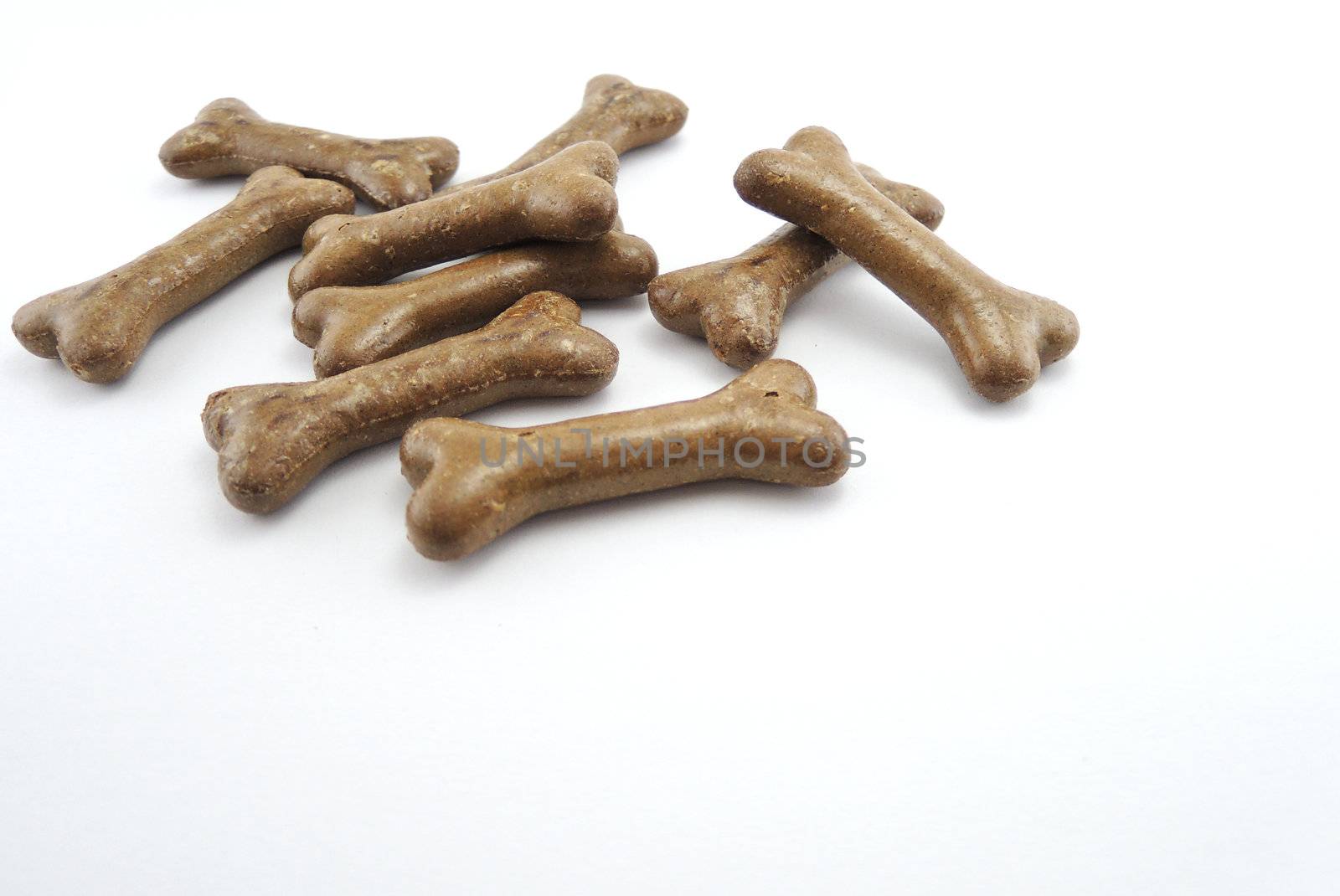 Dog food biscuit shaped like bones isolated on white background by MalyDesigner