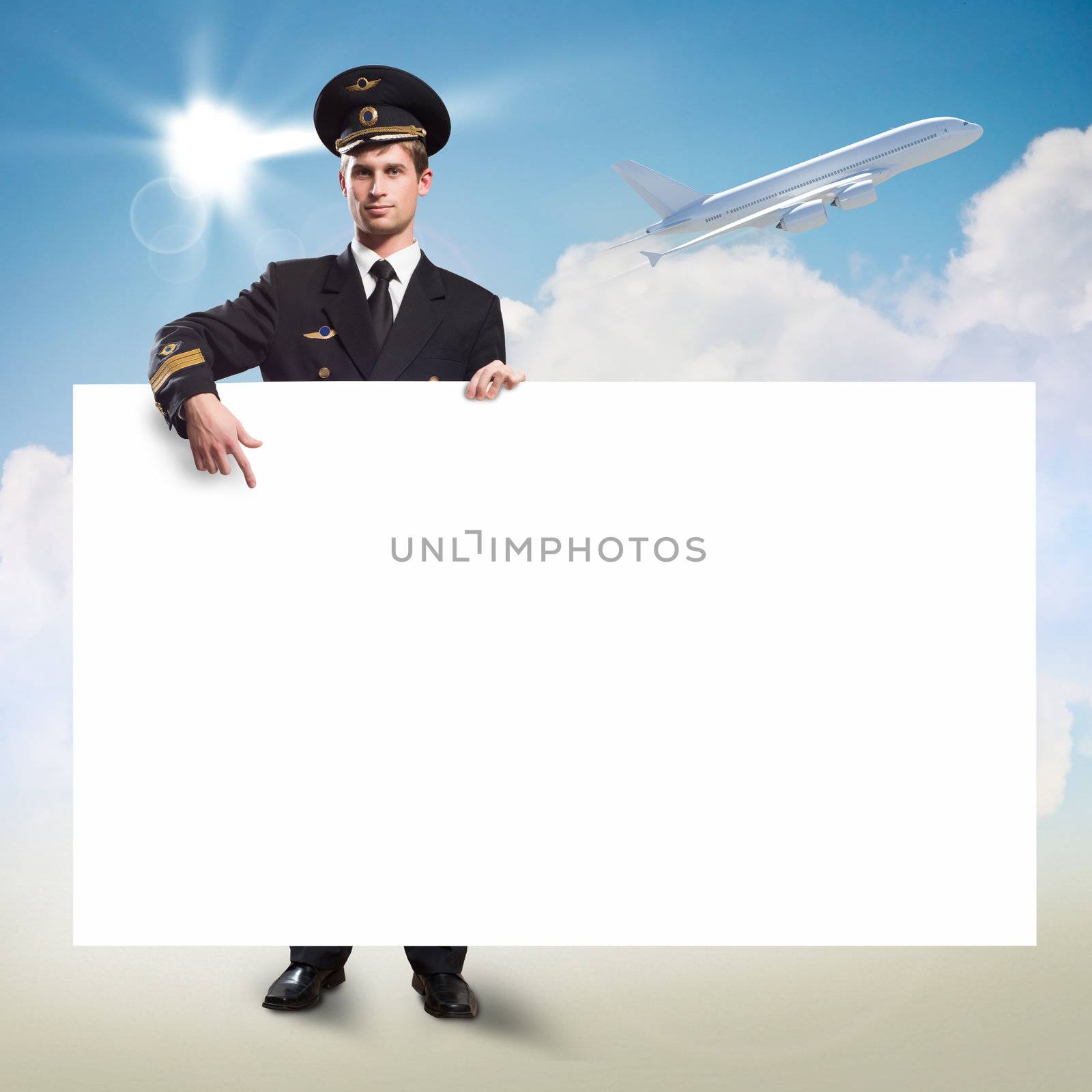 pilot in the form of holding an empty billboard on the background of sky and flying plane, place for text