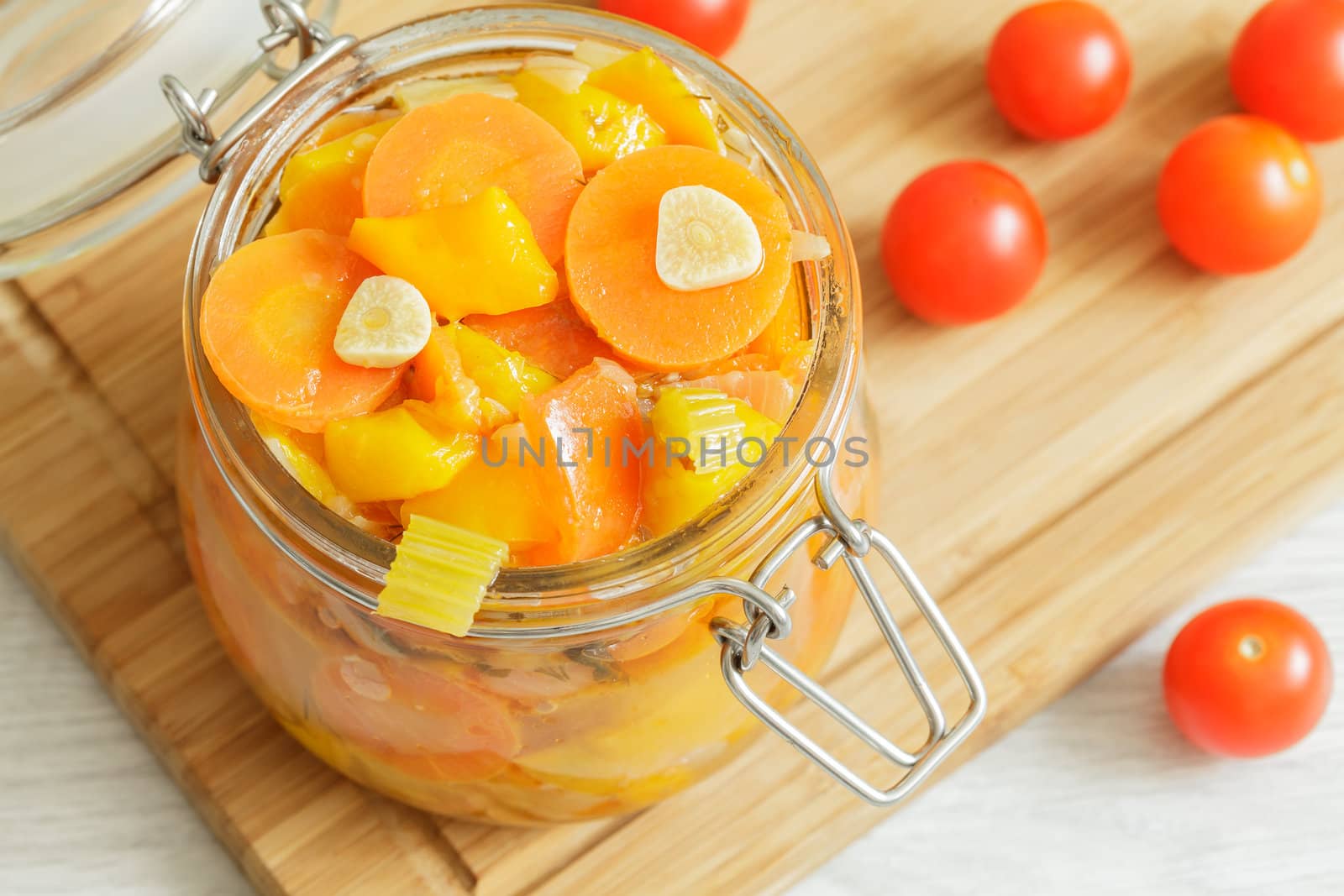 Glass jar with stewed vegetables on the cutting board