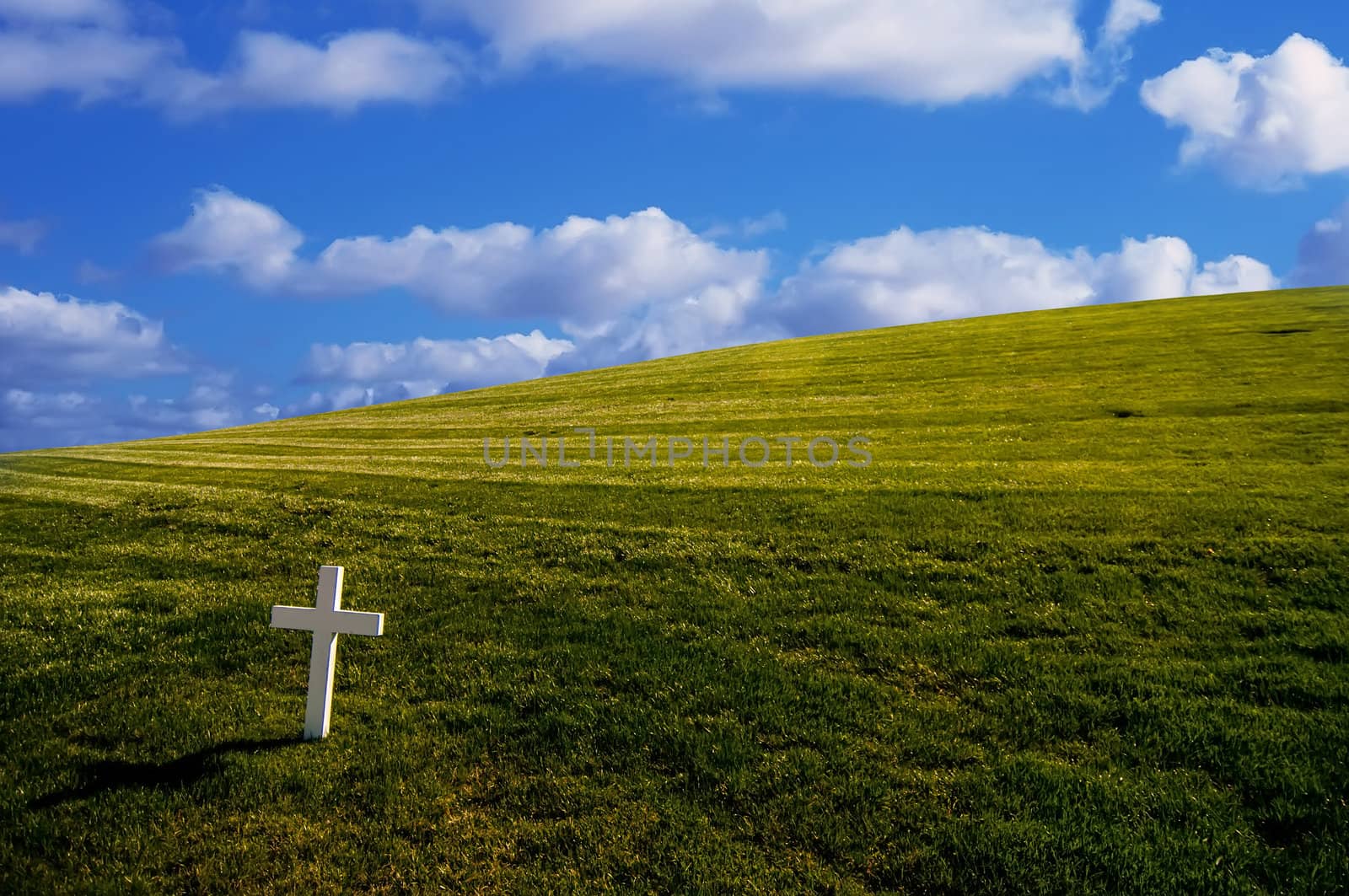 Bright white cross on grassy background.