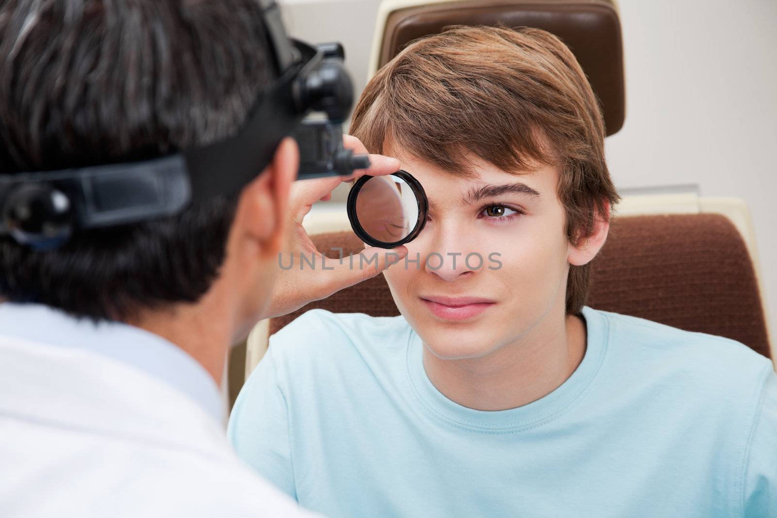 Optometrist taking a closer look at pupil while performing dilated retinal exam