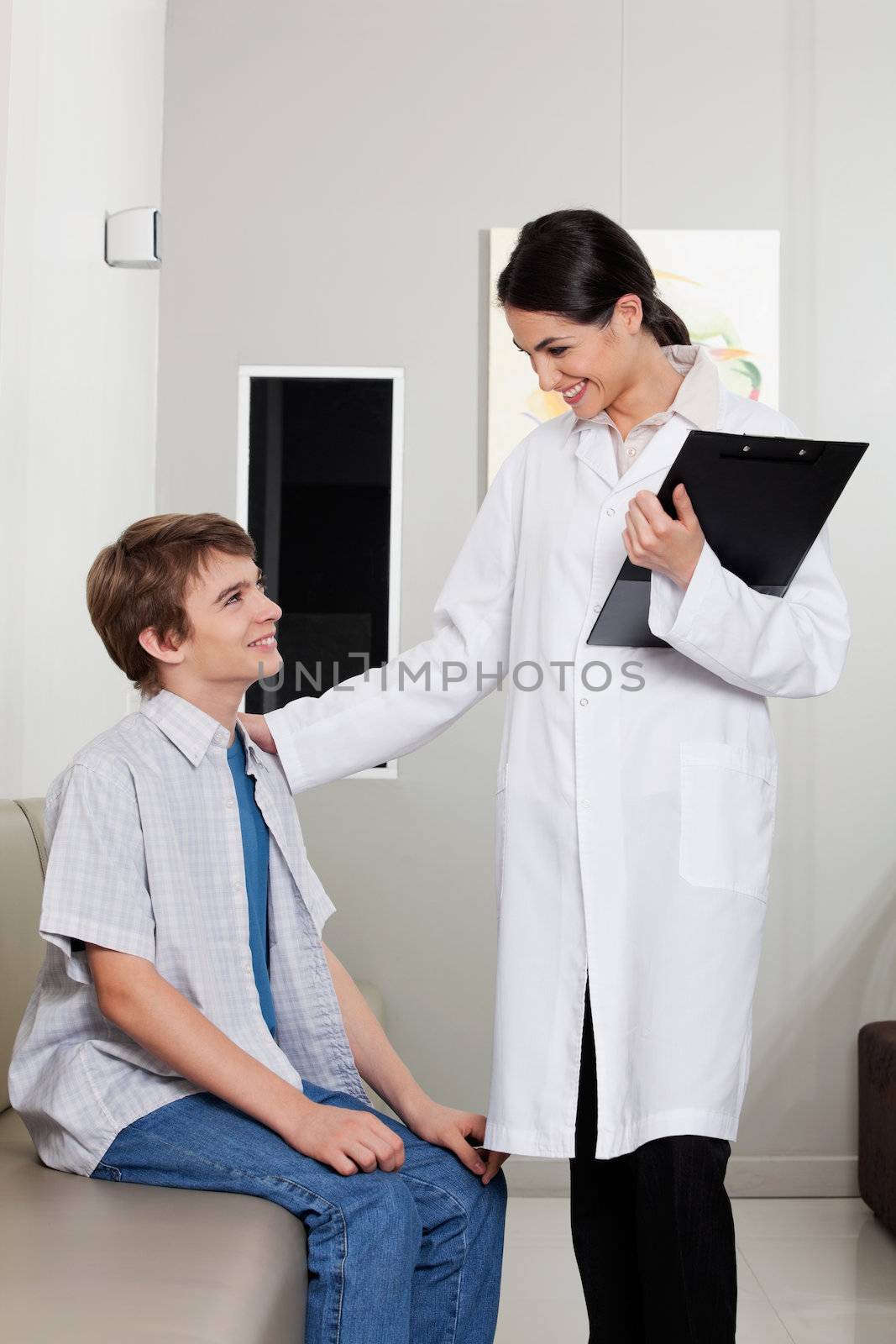 A friendly young optometrist smiling while looking at her patient