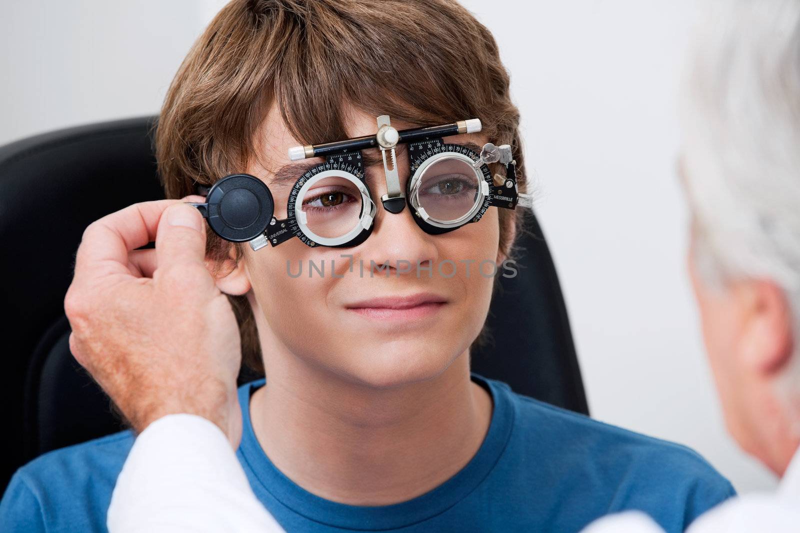 Optometrist taking eye test through trial frames at the clinic