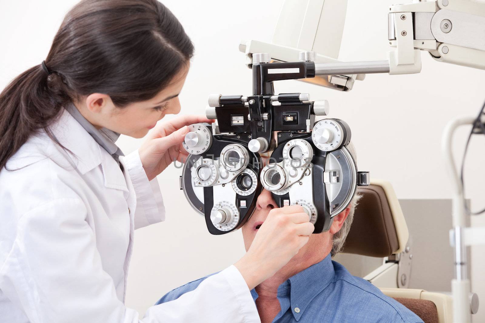 Optometrist doing sight testing for pateient.