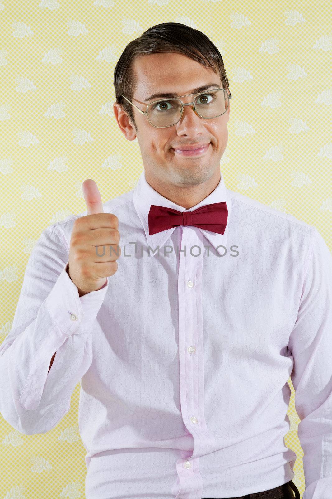 Portrait of young male geek gesturing thumbs up over yellow textured background