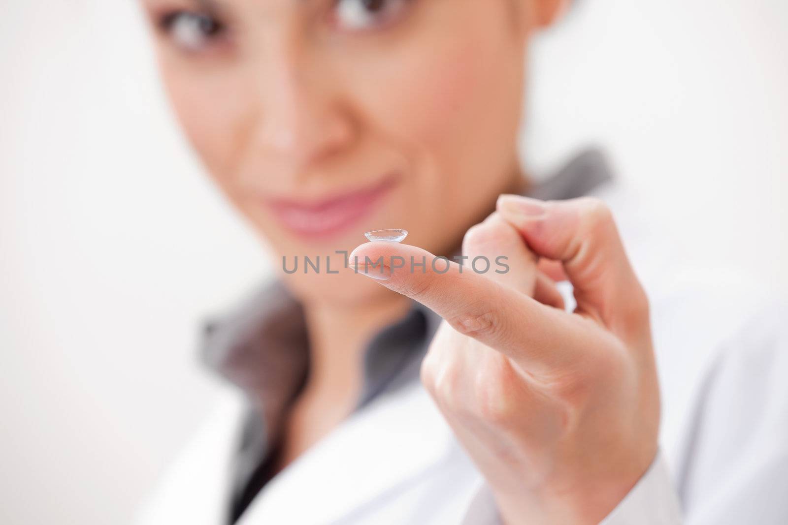 Portrait of a female optometrist showing contact lens