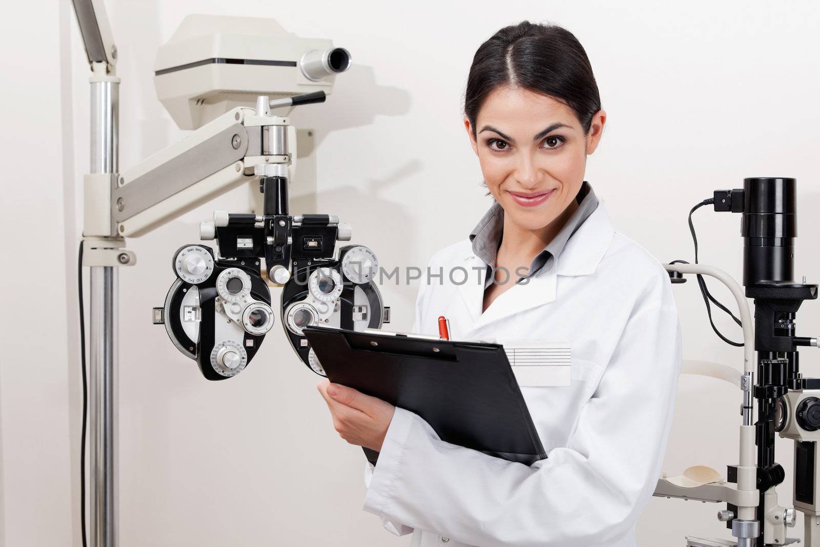 Portrait of a young optometrist smiling with clipboard at clinic