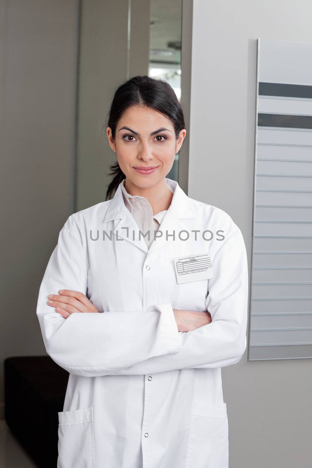 Portrait of a confident female optometrist smiling with arms crossed