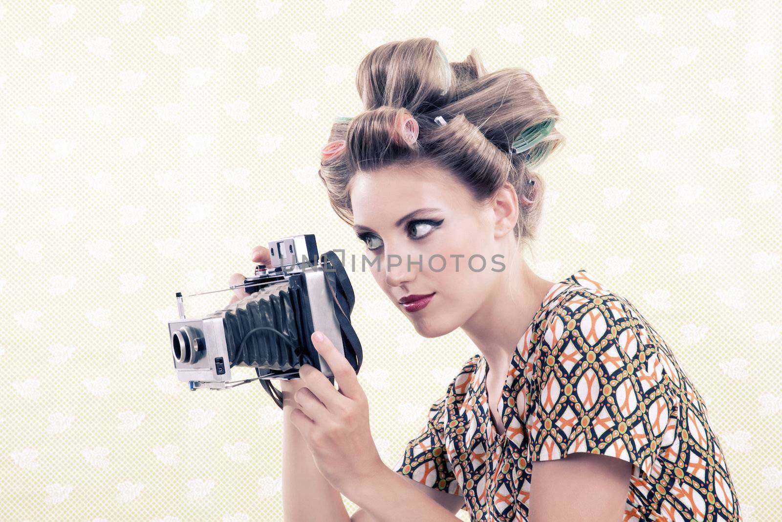 Woman holing vintage 4x6 film camera looking through viewfinder.