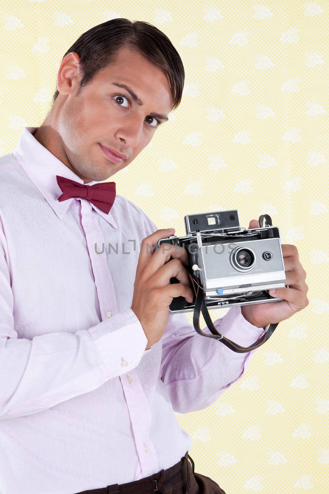 Portrait of a retro styled male holding a medium format antique film camera