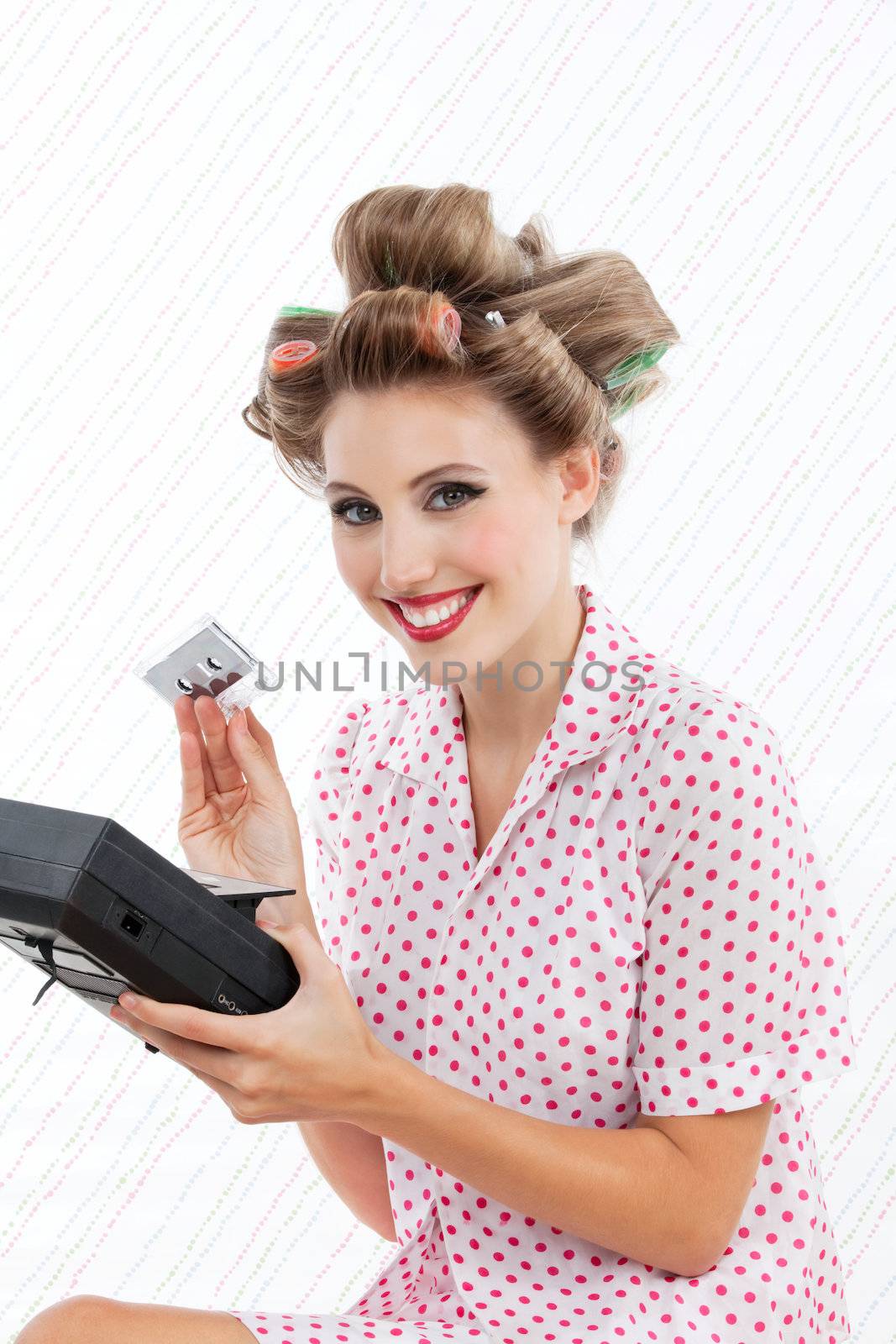 Retro styled woman holding tape recorder and cassette