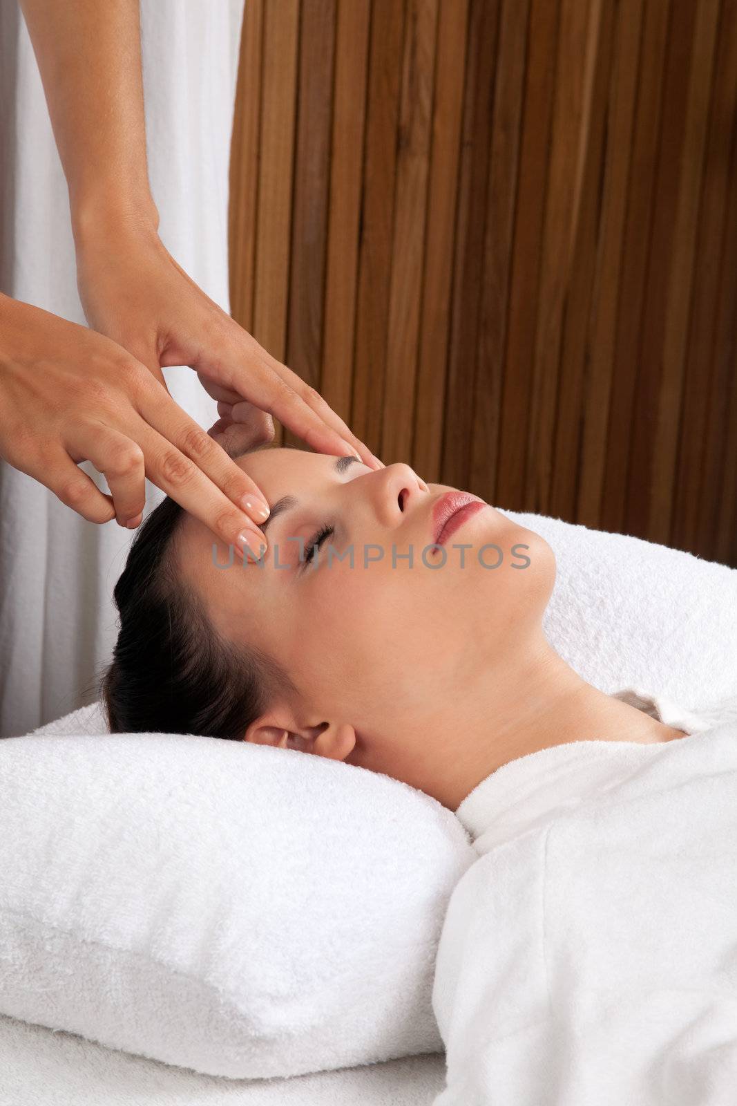 Woman receiving a head massage in spa.