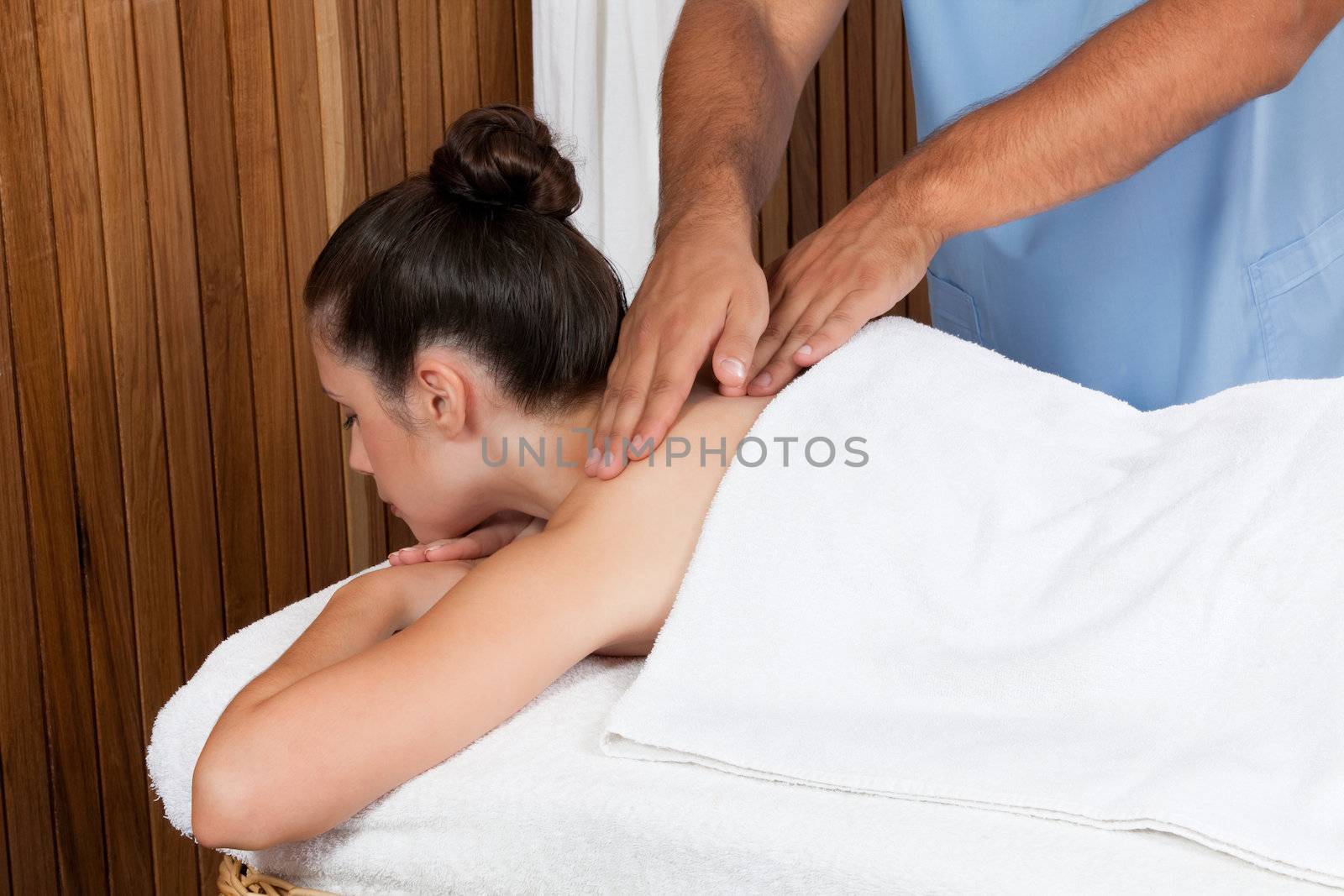 Woman receiving a back massage in spa.