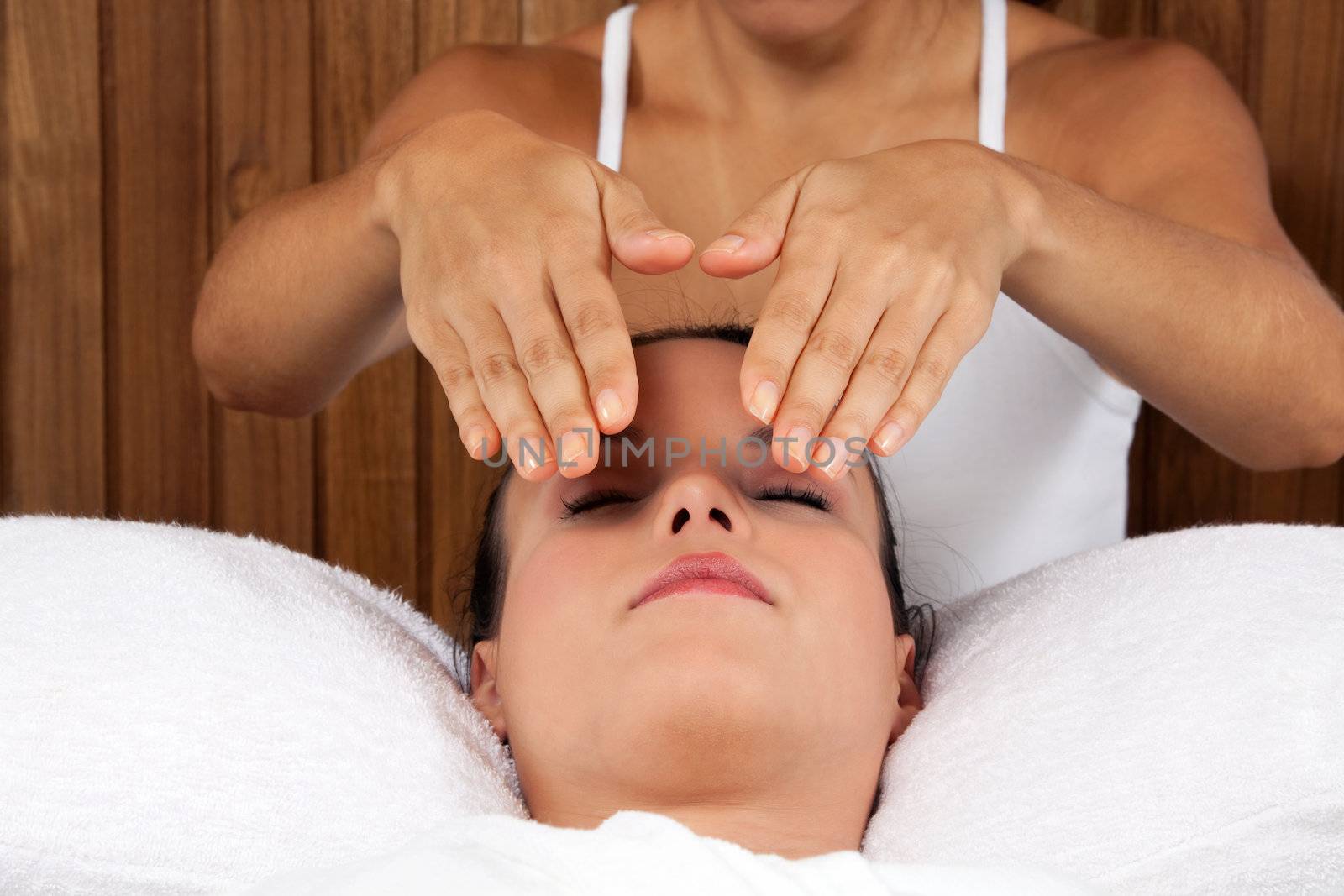 Woman receiving a face massage in spa.