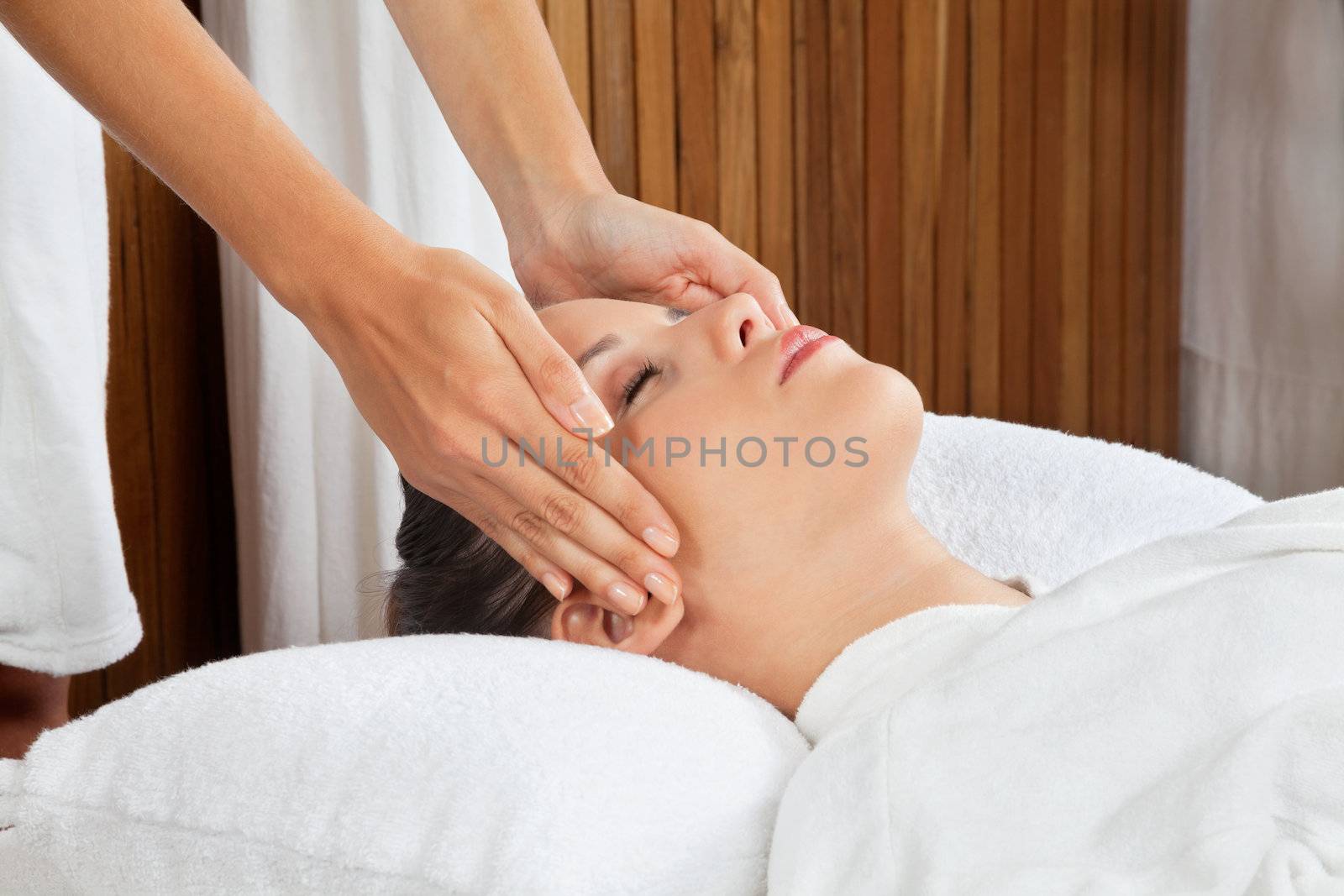 Woman Receiving Head Massage At Spa by leaf