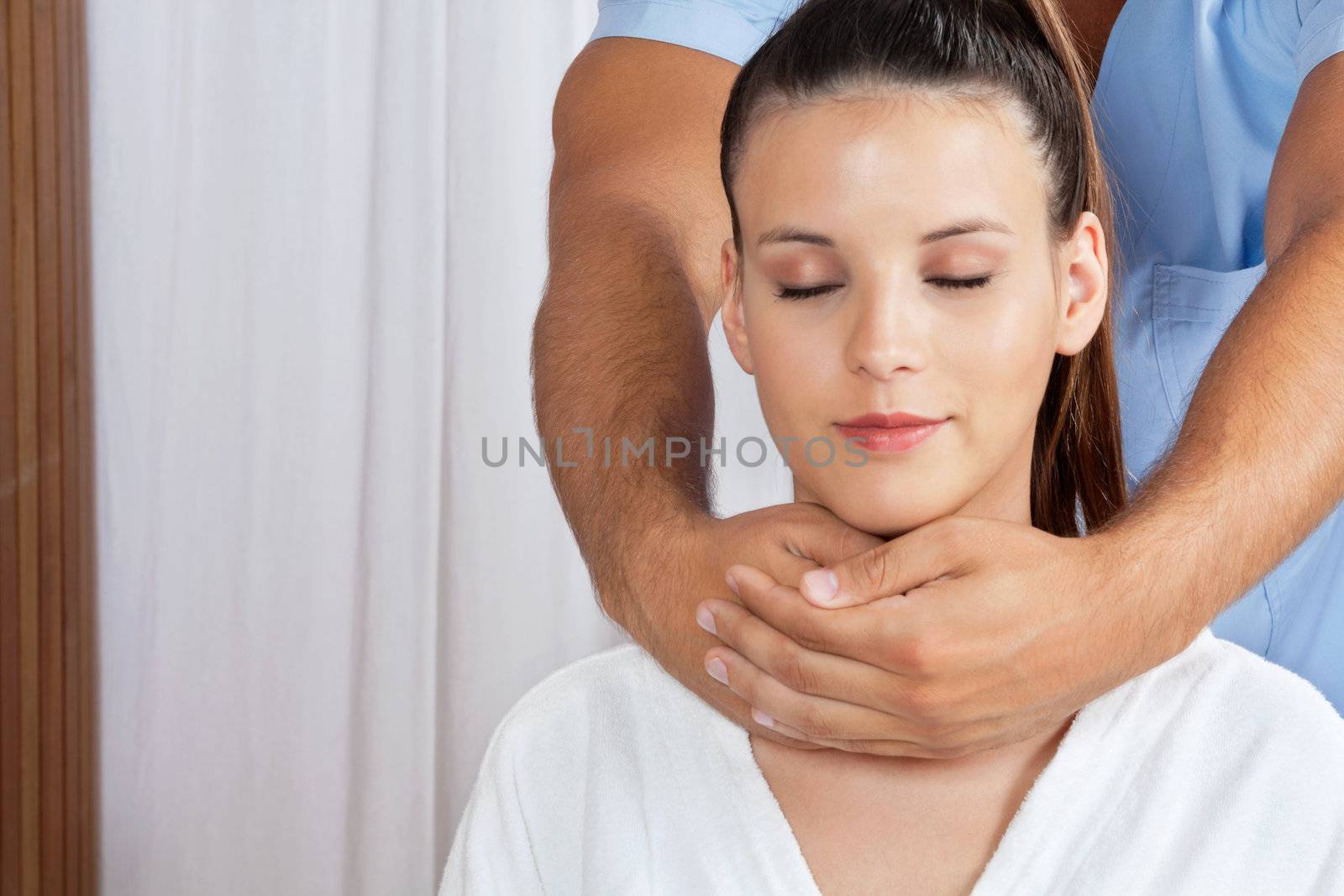Female Receiving Neck Massage by leaf