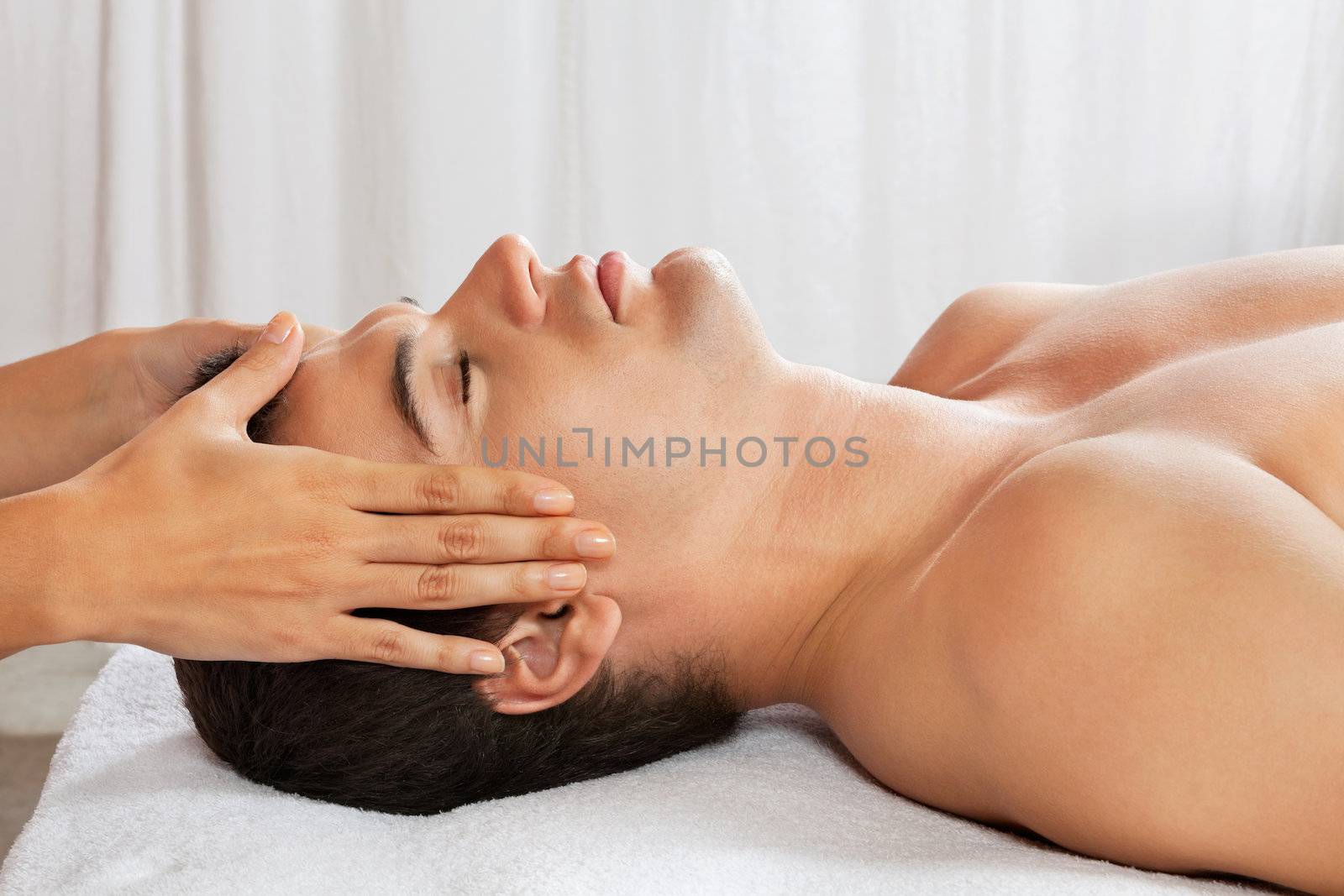 Man Receiving Head Massage At Spa by leaf