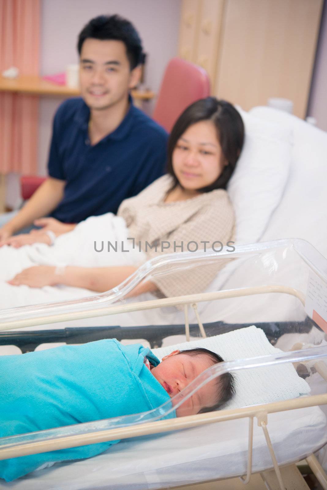 Asian Newborn Infant Baby Girl in Hospital Acrylic Bassinet with parents