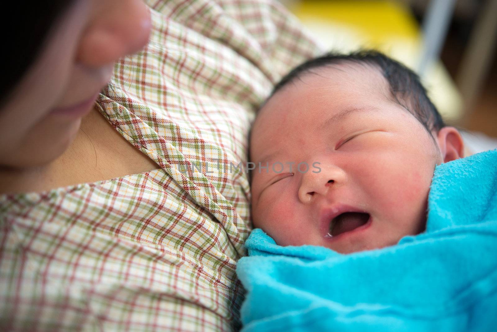 Asian mother and newborn baby girl in hospital