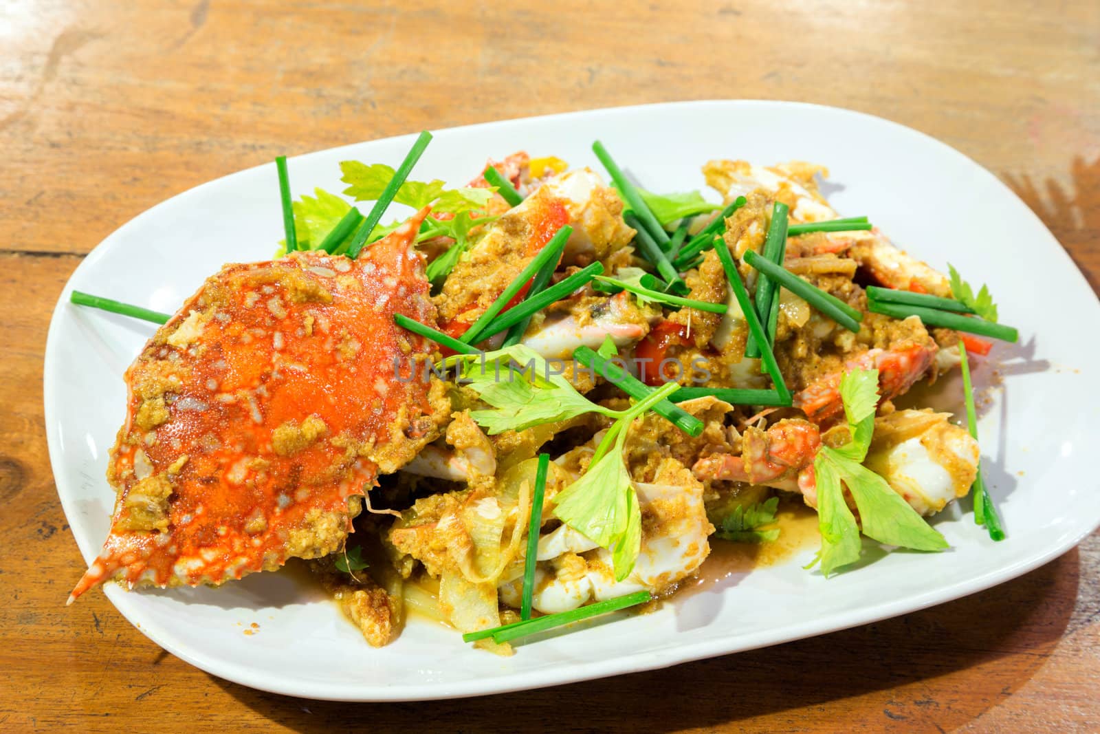cooked curry crabs with spicy sauce on white plate