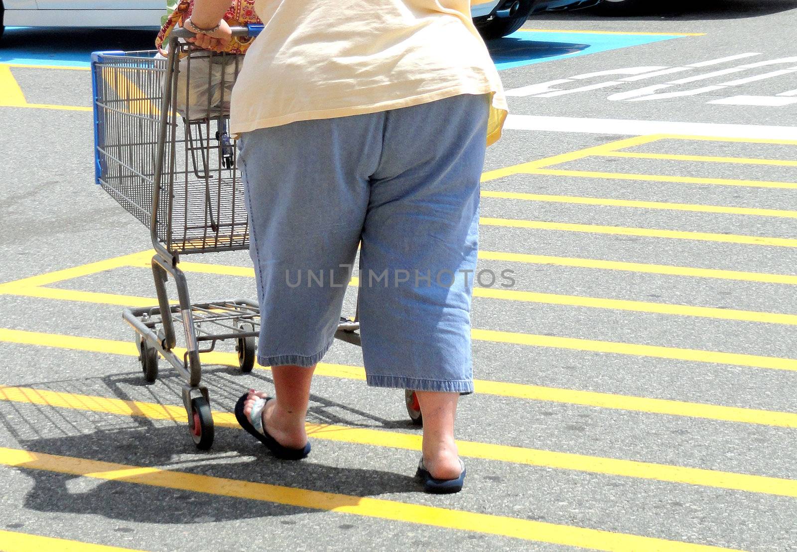 Overweight woman walking to her car in the shopping center.