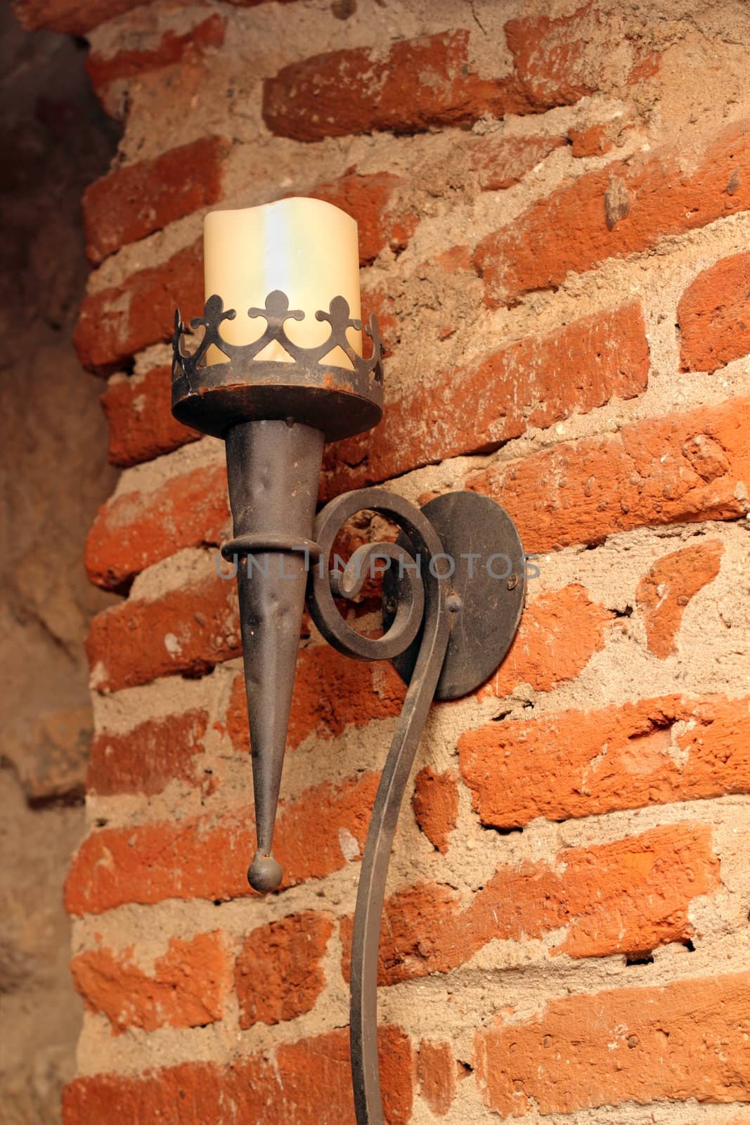 torch with candlelight on the grunge wall of the basement of an old castle