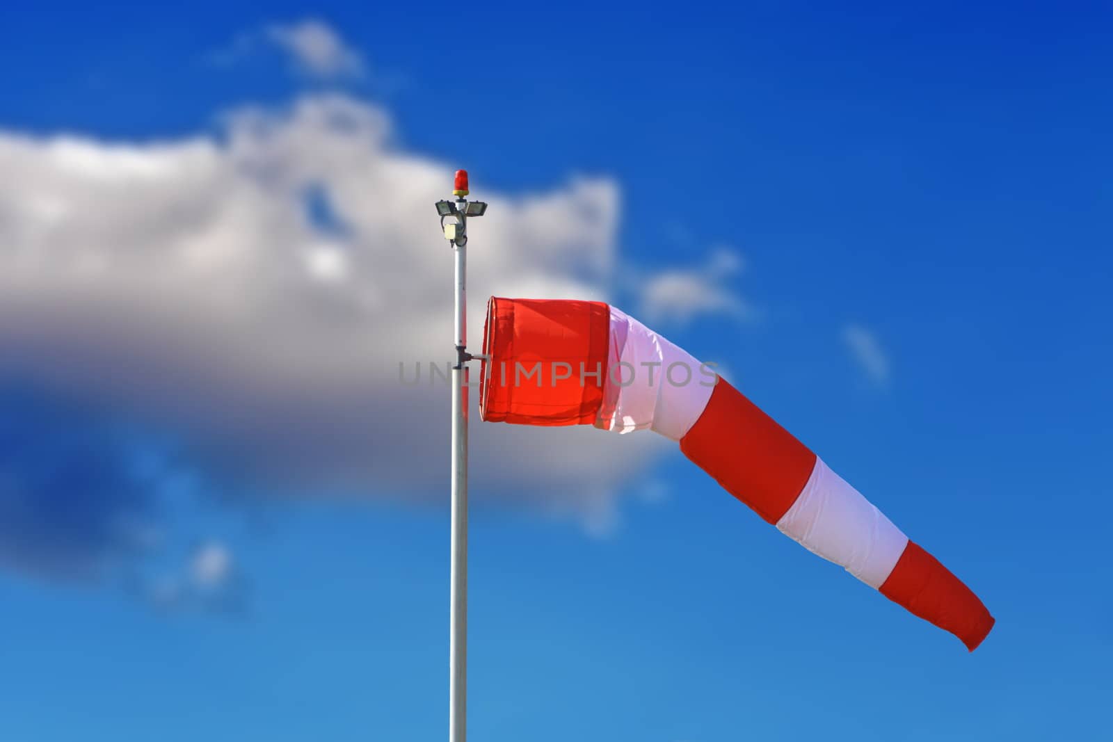 red and white windsock over blue sky at the airport