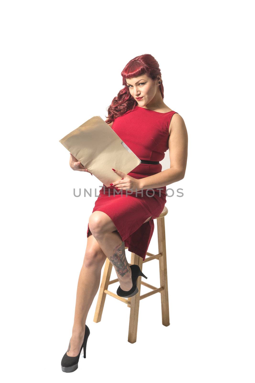 Sexy red headed business woman in red dress holding legal documents. Isolated on white background