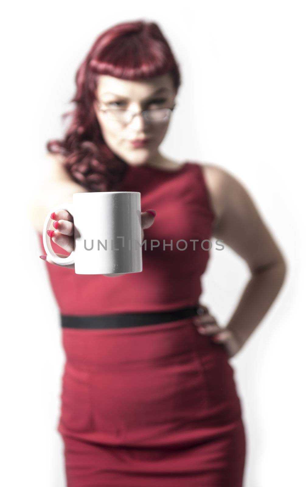 Coffee cup held up with out of focus red headed sexy business woman in the background. Isolated on white background