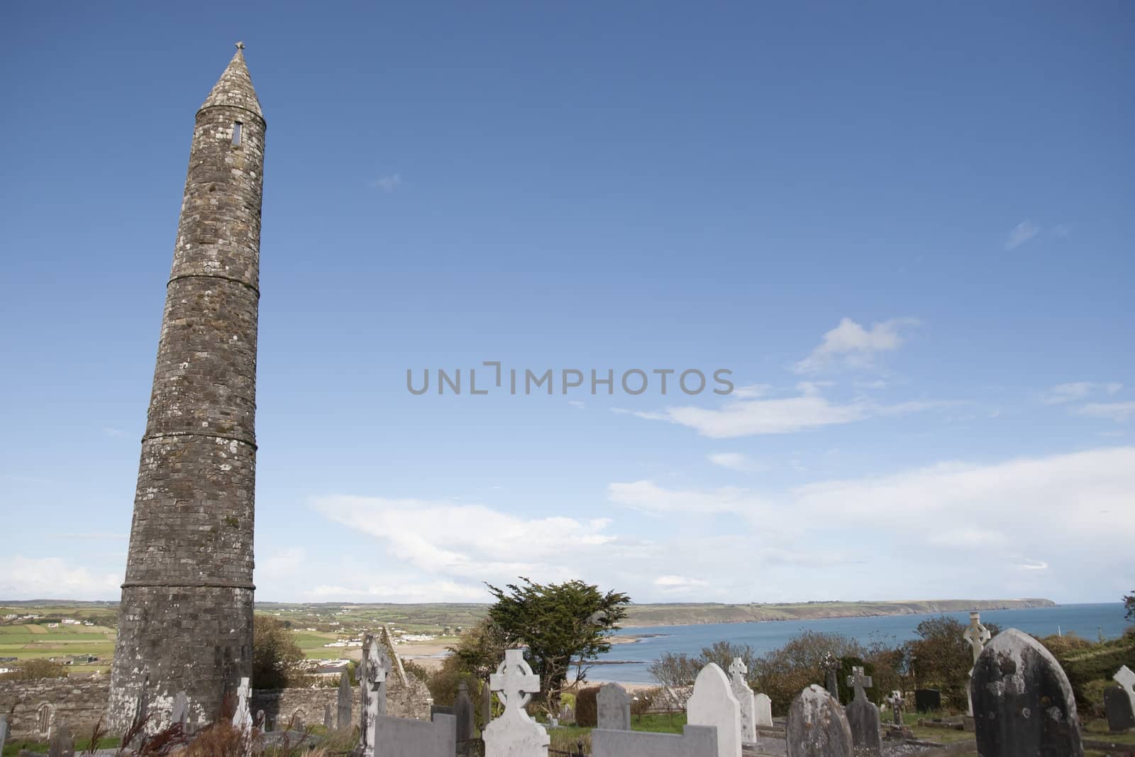 Ancient round tower and celtic graveyard with cathedral in Ardmore county Waterford, Ireland