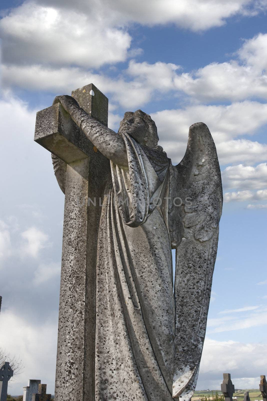 Angel statue embracing a cross by morrbyte