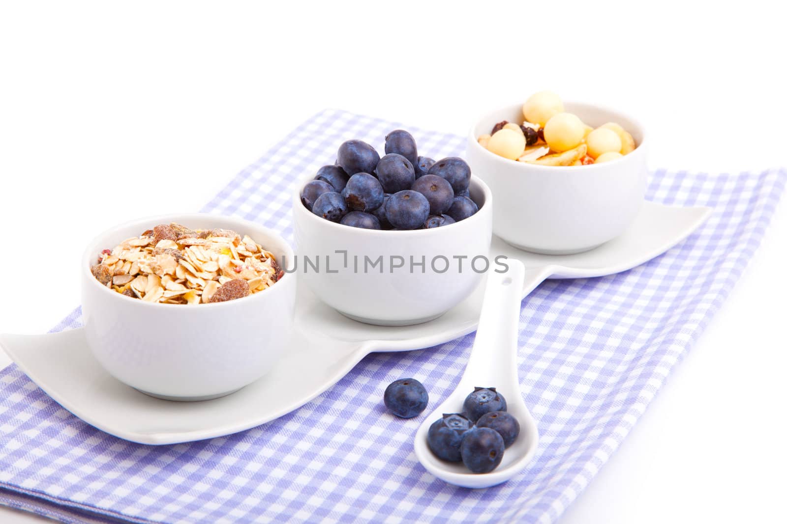 fresh blueberry with porcelain spoon, corn flakes and serviette. on white background.