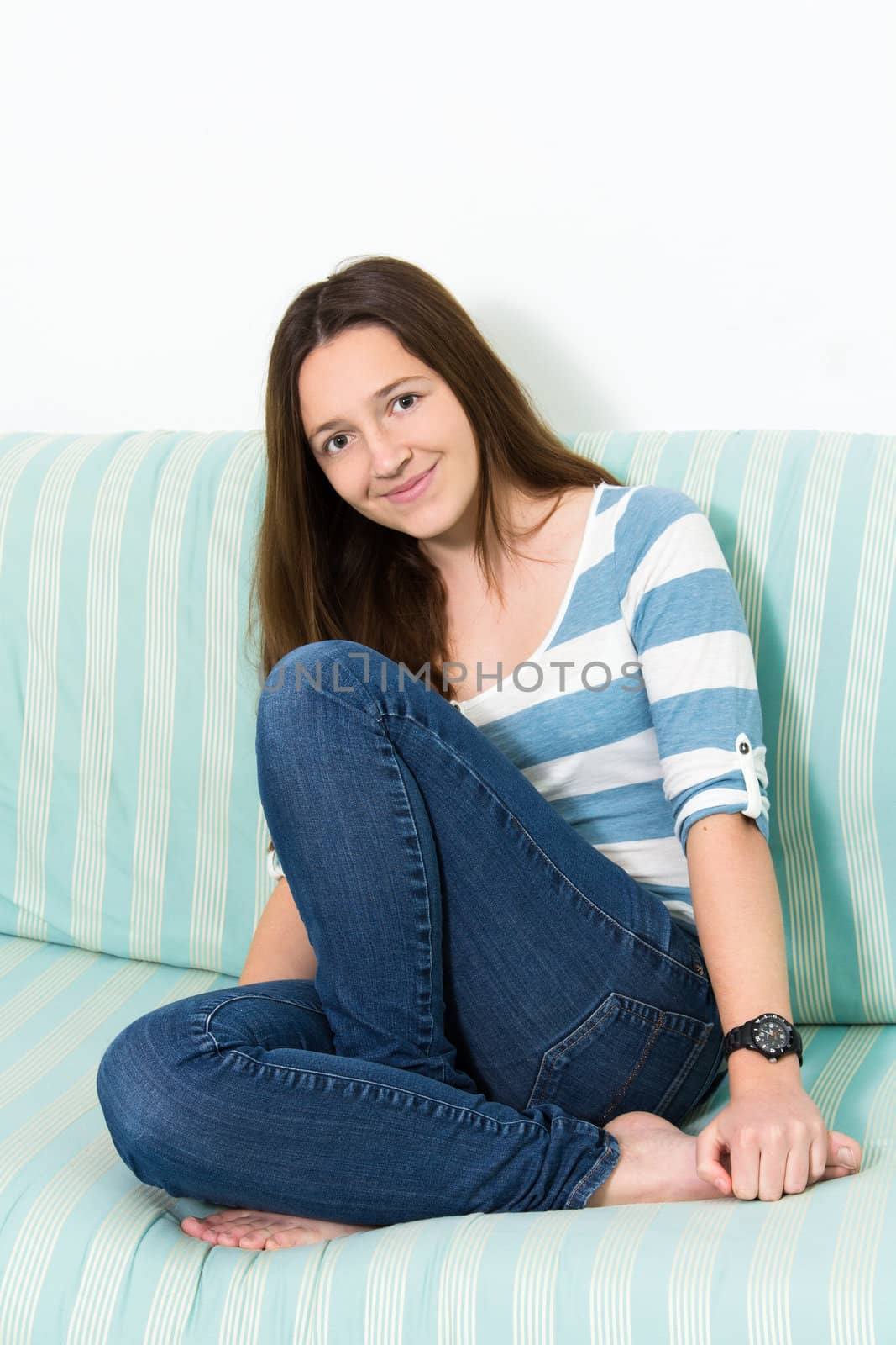 Young Brunette Teenager wearing blue jeans looking at camera