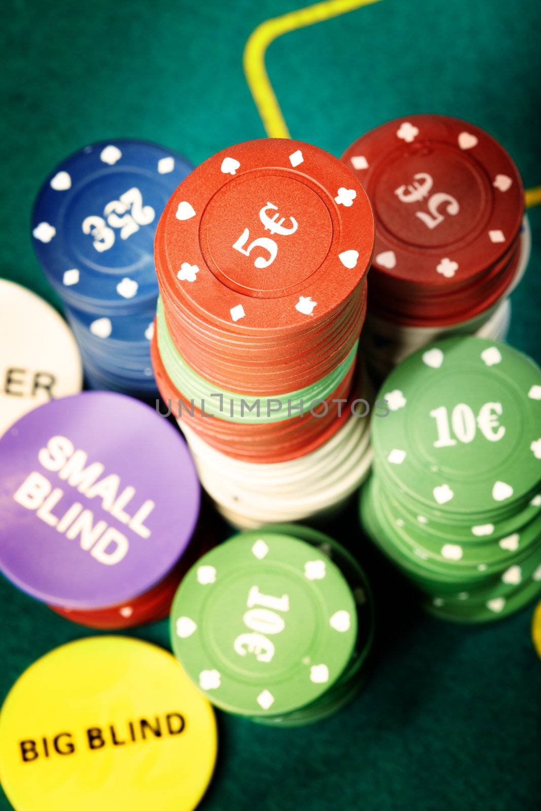 Stack of poker chips on a green table of casino