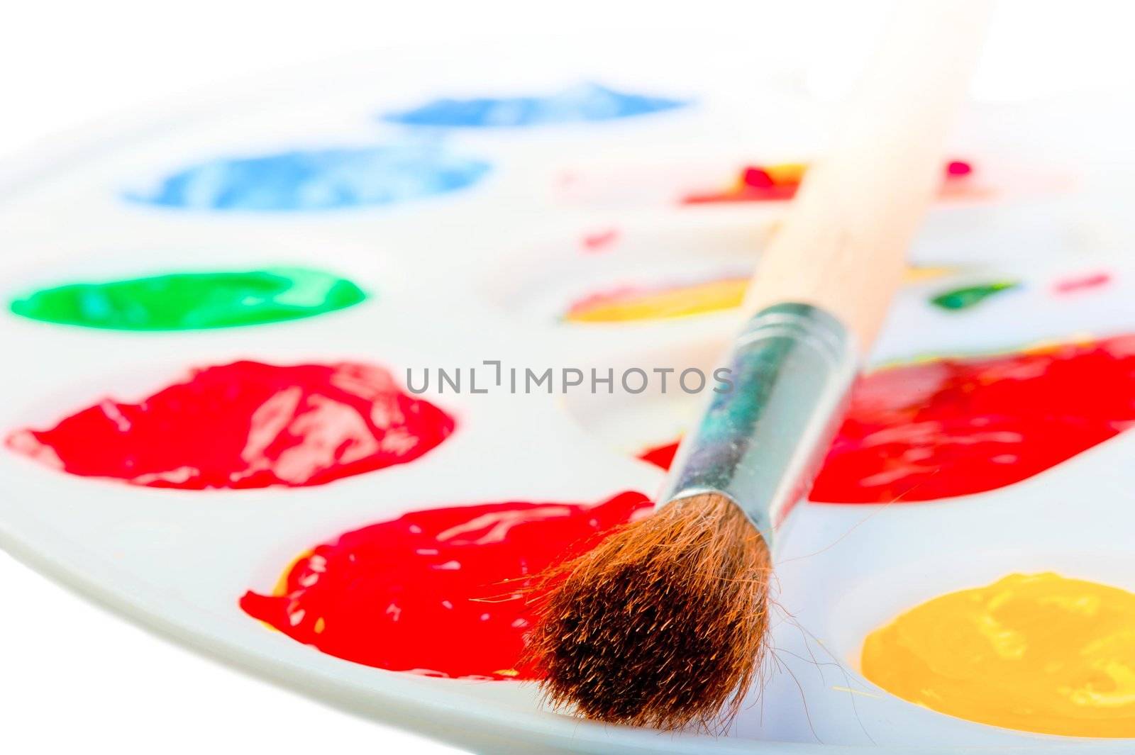 Artist's brush on a white palette with paints by kosmsos111