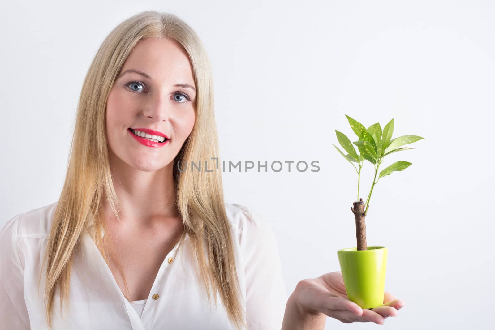 Young woman with small tree smiling happily