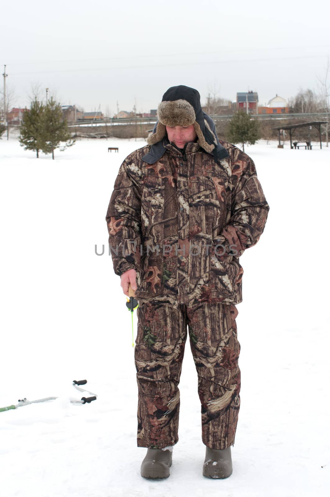 The man catches fish on lake ice.