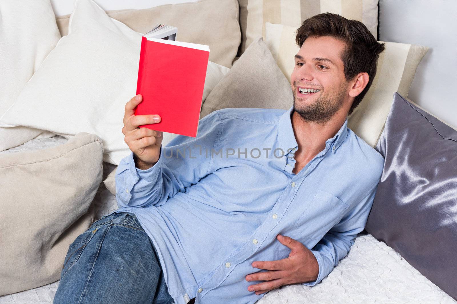 Young Brunette Man in Blue Shirt Reading A Book