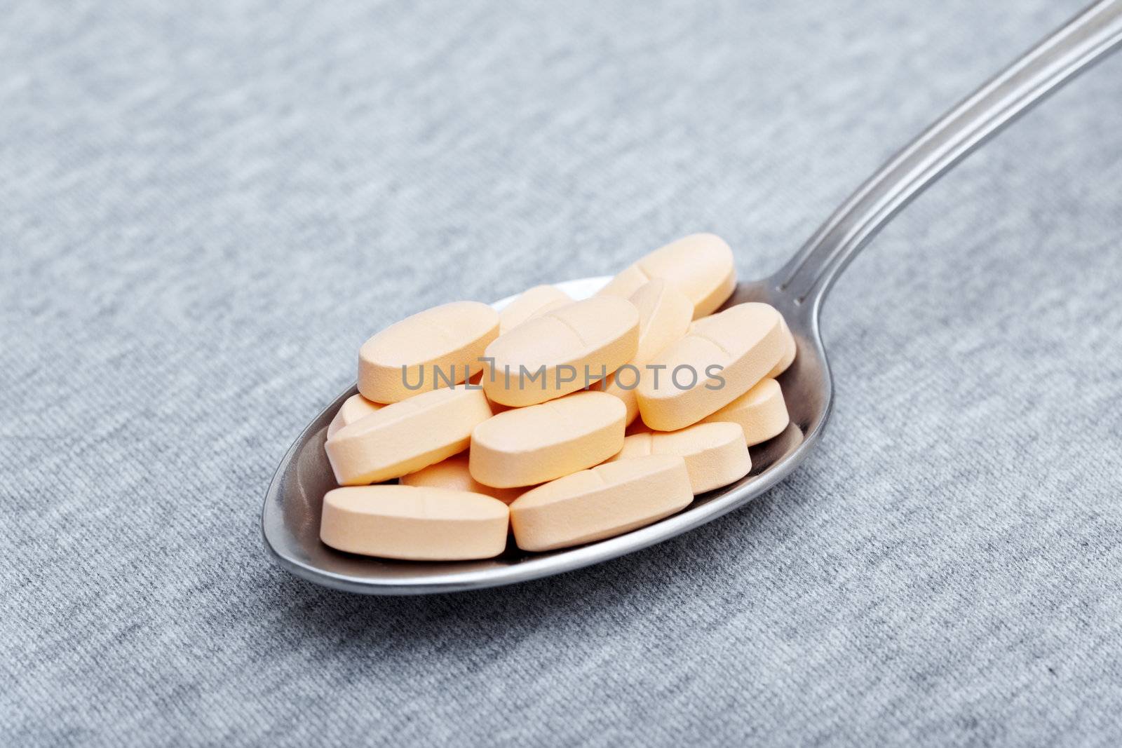 Medical pills on a metal spoon. Close-up photo